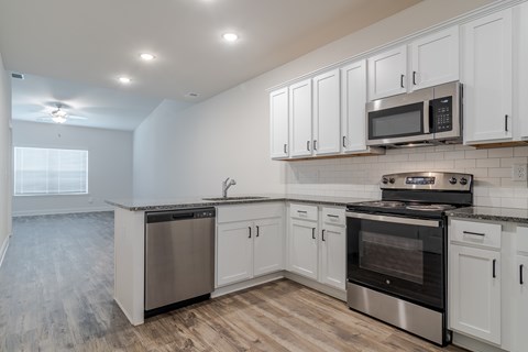 A kitchen with white cabinets and stainless steel appliances.