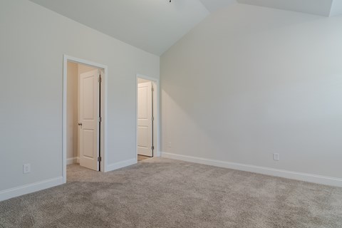 A room with two doors and carpeted floor.