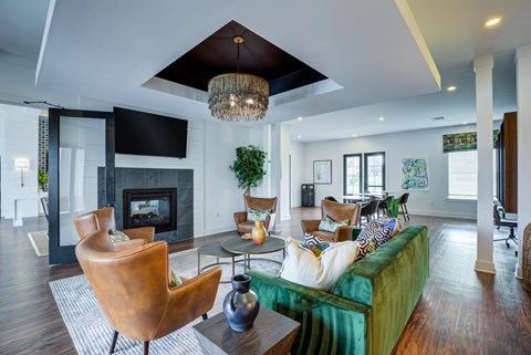 A living room with a green couch and a fireplace.