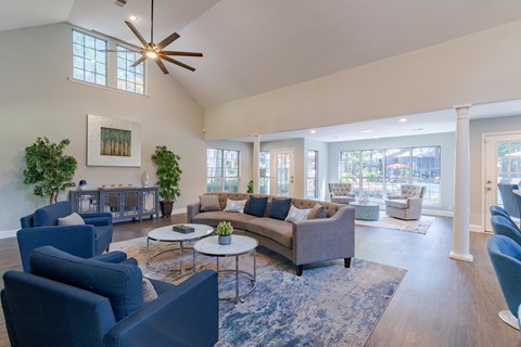 A living room with a grey couch and blue chairs.