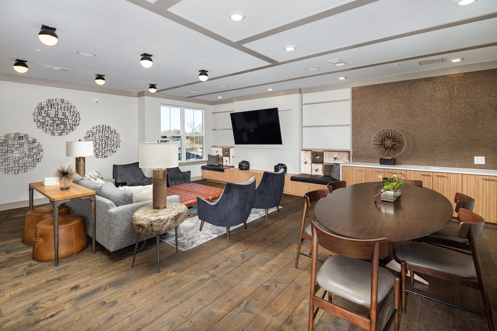 a resident clubhouse with a table and chairs and a couch at The Flats at Southlawn Apartments, Georgia