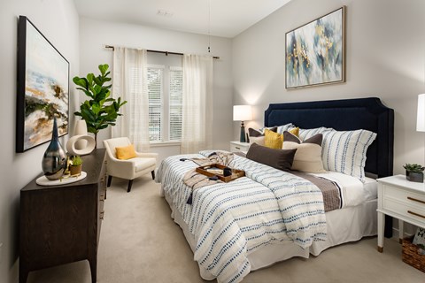 A bedroom with a large bed and a painting on the wall.
