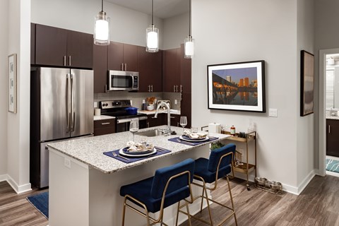 A kitchen with a table and chairs and a fridge.