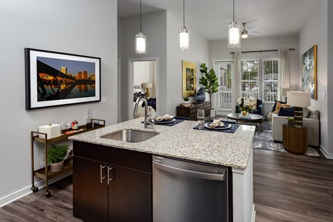 A modern kitchen with a large island and a framed picture on the wall.
