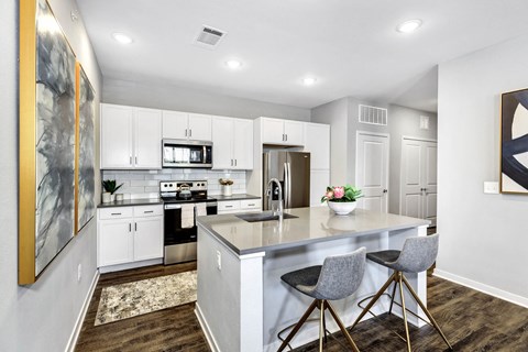 a kitchen with white cabinets and a white counter top at Farmhaus Apartments, Madison, 35757