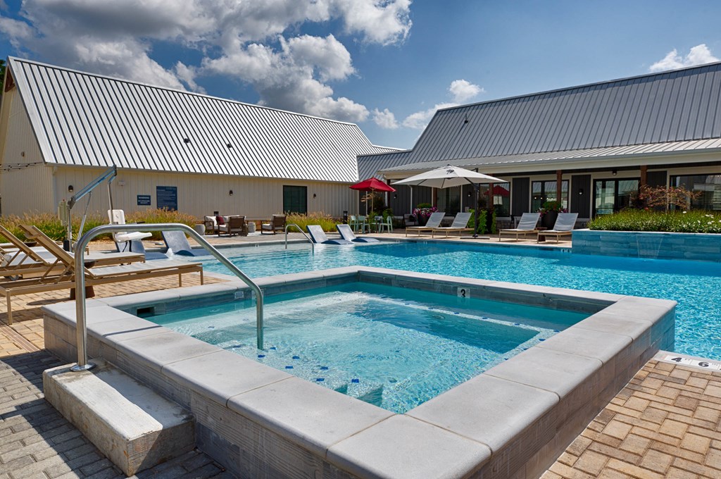people are standing around a swimming pool at Farmhaus Apartments, Madison, 35757