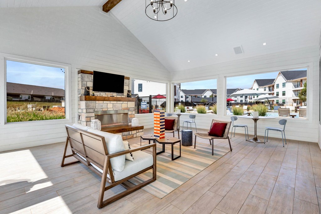 a dining room with a table and chairs in a room with large windows at Farmhaus Apartments, Madison, Alabama