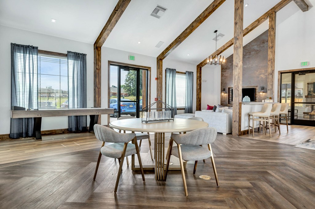 a dining area with a table and chairs and a living room with a fireplace at Farmhaus Apartments, Madison, 35757