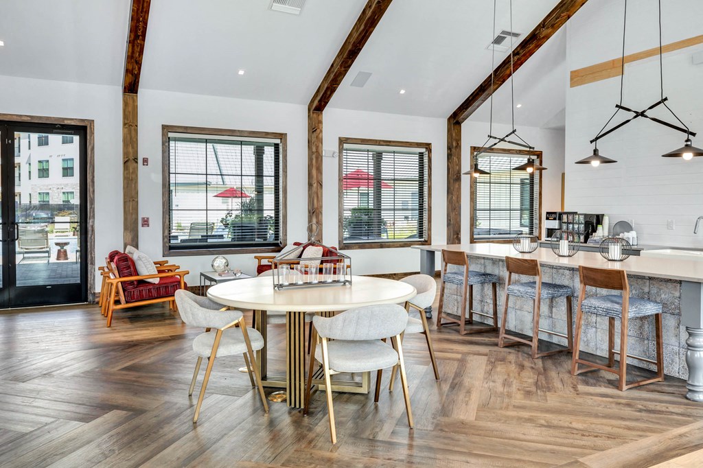 a dining area with a round table and chairs and a window at Farmhaus Apartments, Alabama, 35757
