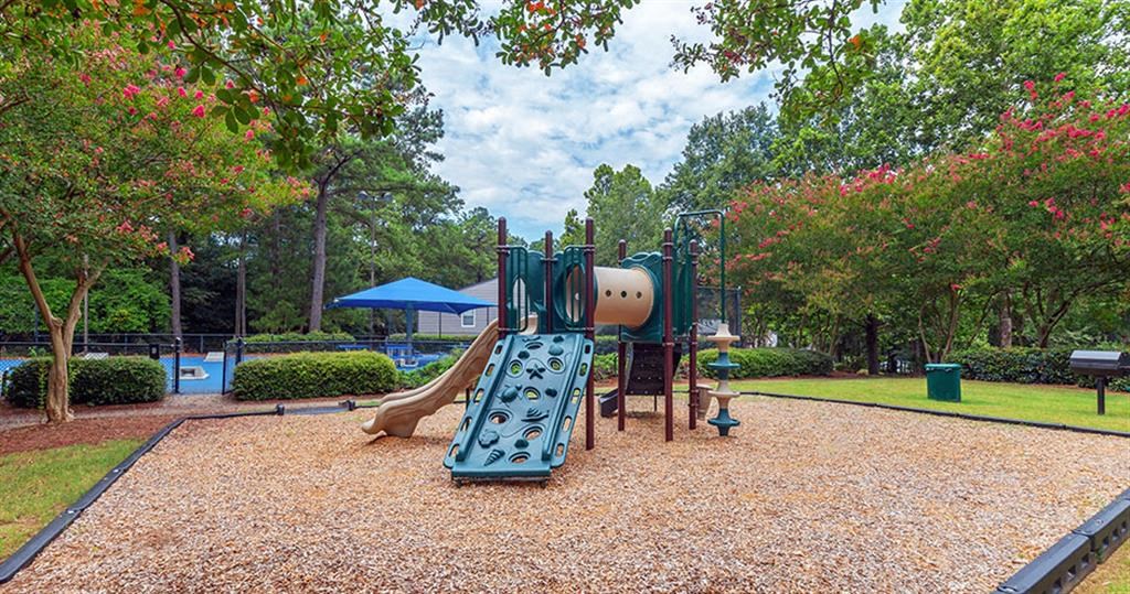 a playground with a swing set and a slide in a park at High Ridge Apartments, Athens, 30606
