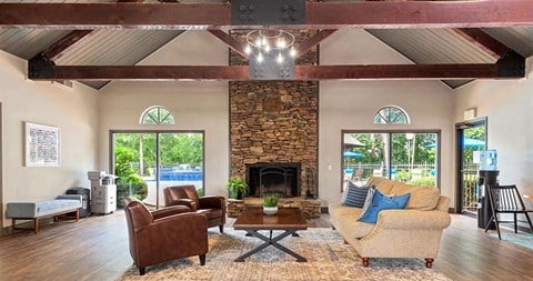 a living room with a large stone fireplace and furniture