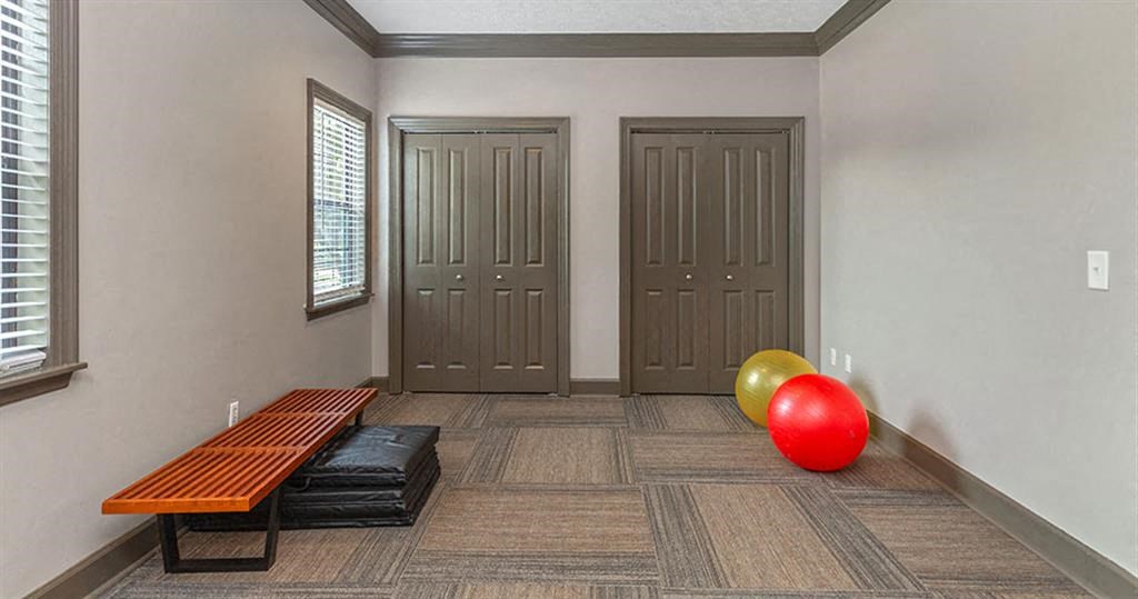 a room with two doors and a red ball and a bench  at High Ridge Apartments, Athens, GA 30606