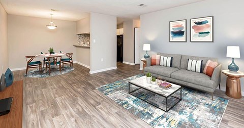 A living room with a grey couch, a coffee table, and a dining table with chairs.