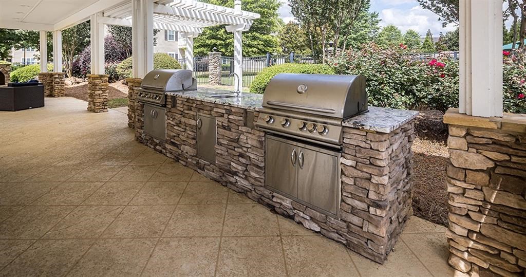 an outdoor kitchen with two grills on a patio at Bedford Parke Apartments, Georgia, 31088