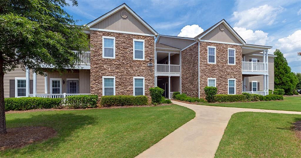 an apartment building with a sidewalk in front of it at Bedford Parke Apartments, Warner Robins Georgia