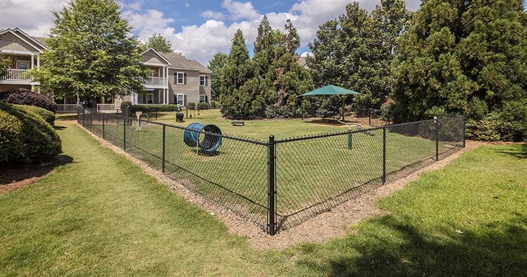 a yard with a chain link fence and a playground at Bedford Parke Apartments, Warner Robins, 31088