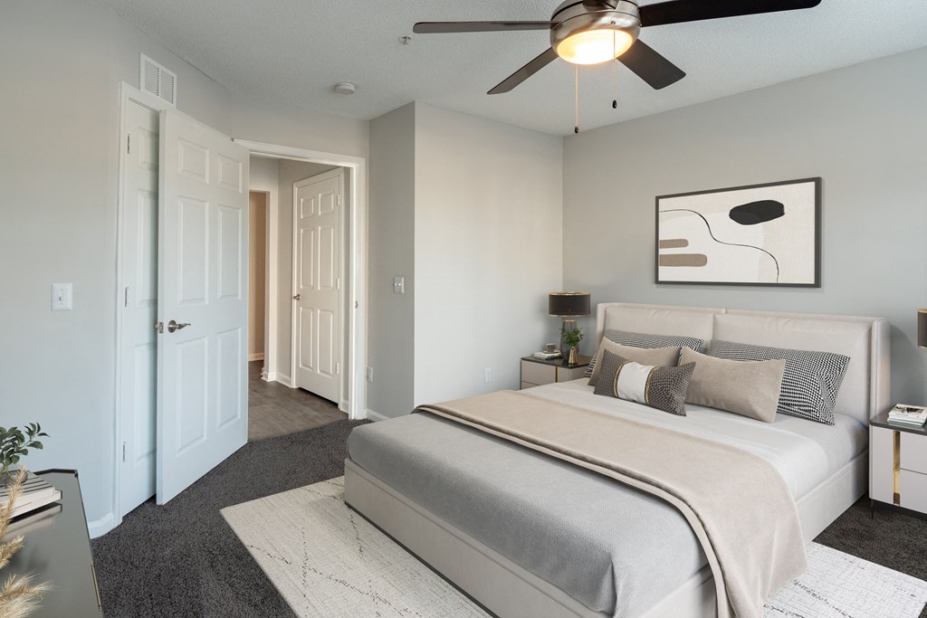 A bedroom with a large bed and a ceiling fan