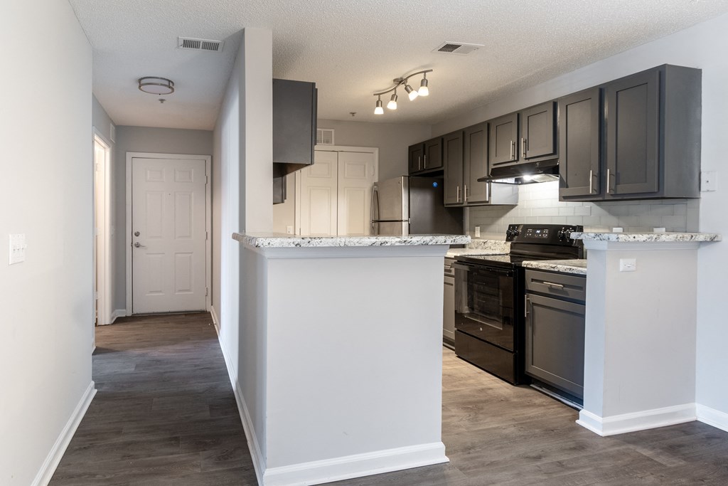 A kitchen with black cabinets and a white countertop