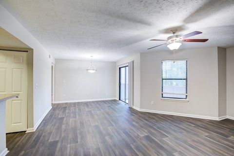 A room with a ceiling fan and a window with blinds.