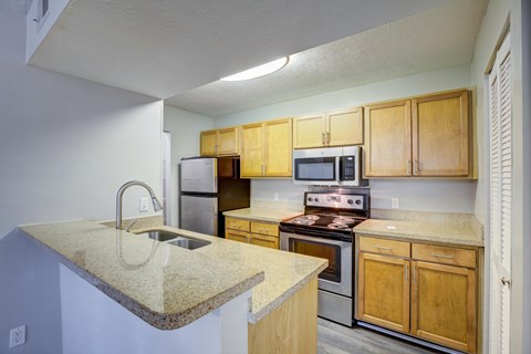 A kitchen with wooden cabinets and a granite countertop.