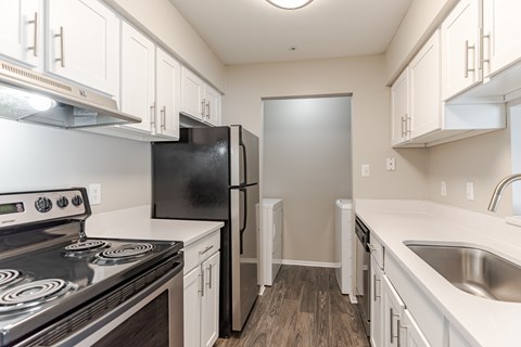 A kitchen with black appliances and white cabinets.