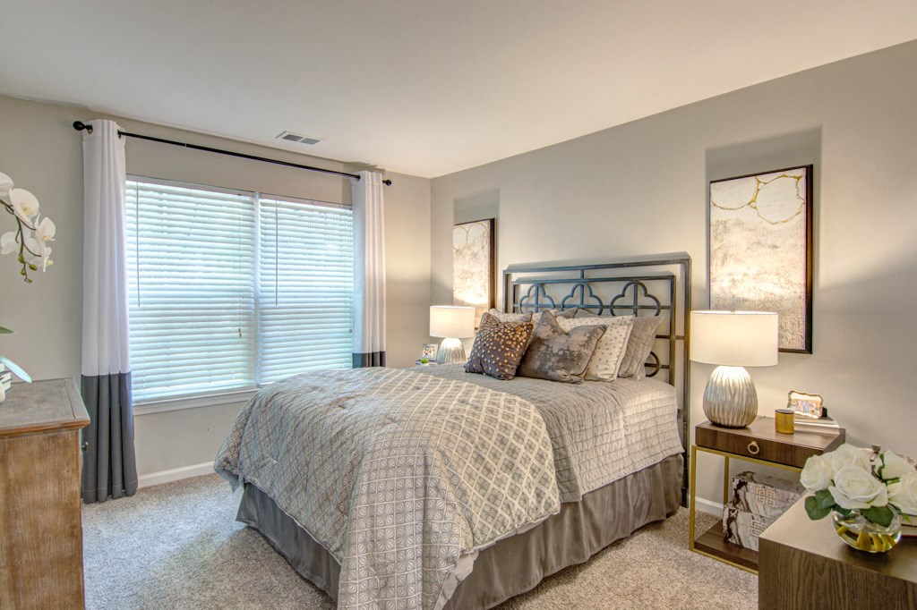 a bedroom with a bed and two night stands with lamps at Hunters Chase Apartments, Virginia,23112