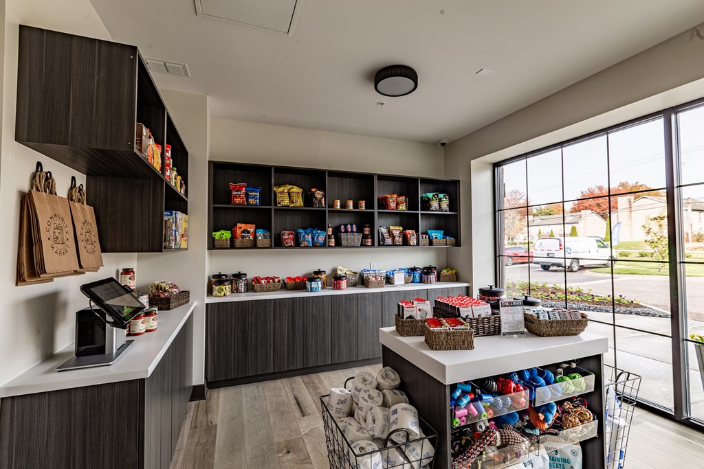 a store with a large window and a counter filled with bags and baskets of food at The Louis Apartment Flats, Louisville, 40241