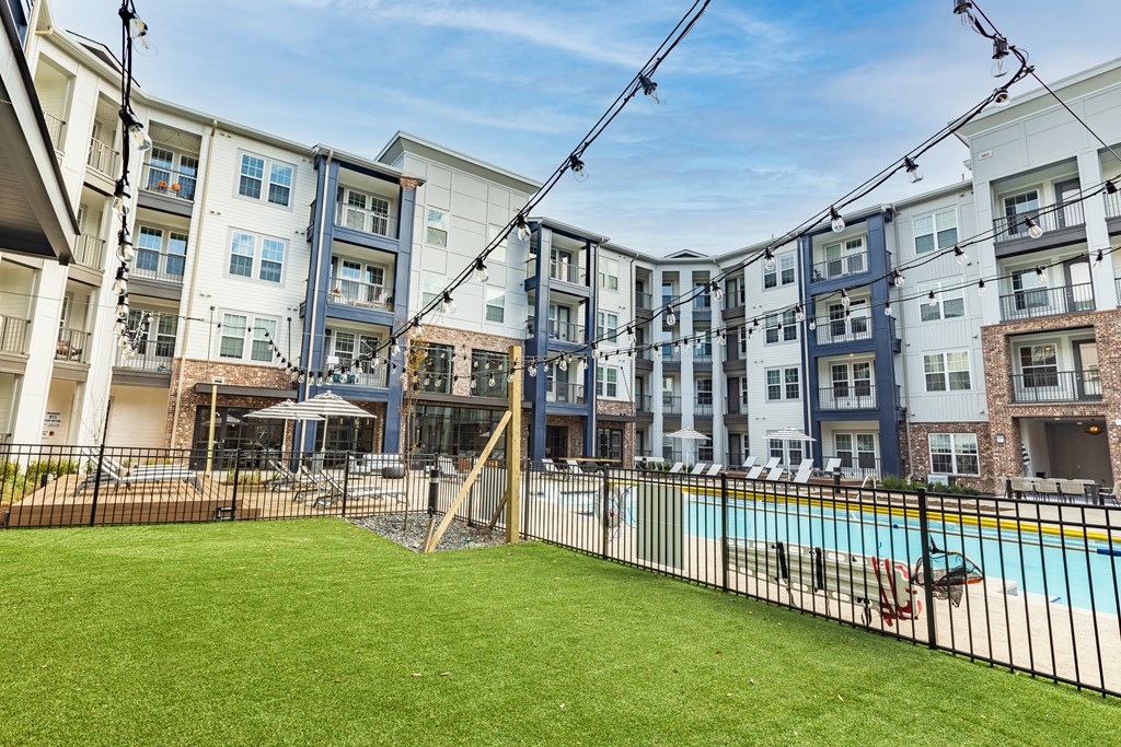 an apartment building with a swimming pool and a fenced in yard at The Louis Apartment Flats, Kentucky, 40241