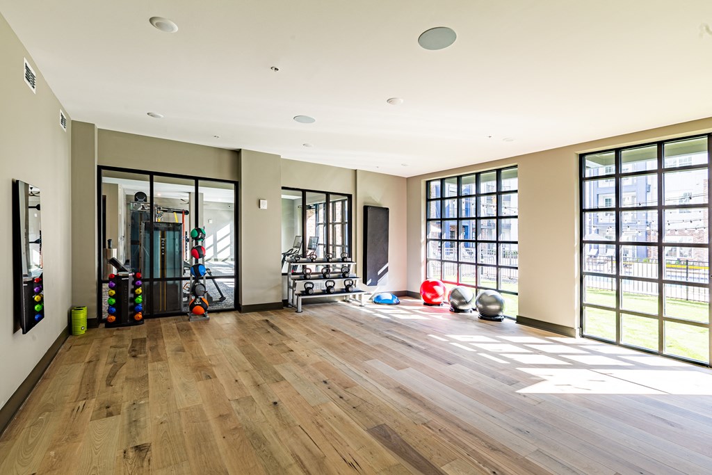 a workout room with a wood floor and large windows at The Louis Apartment Flats, Louisville, KY, 40241
