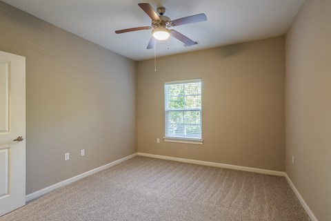 A room with a ceiling fan and a window.