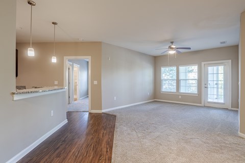 A spacious room with a ceiling fan and a large window.