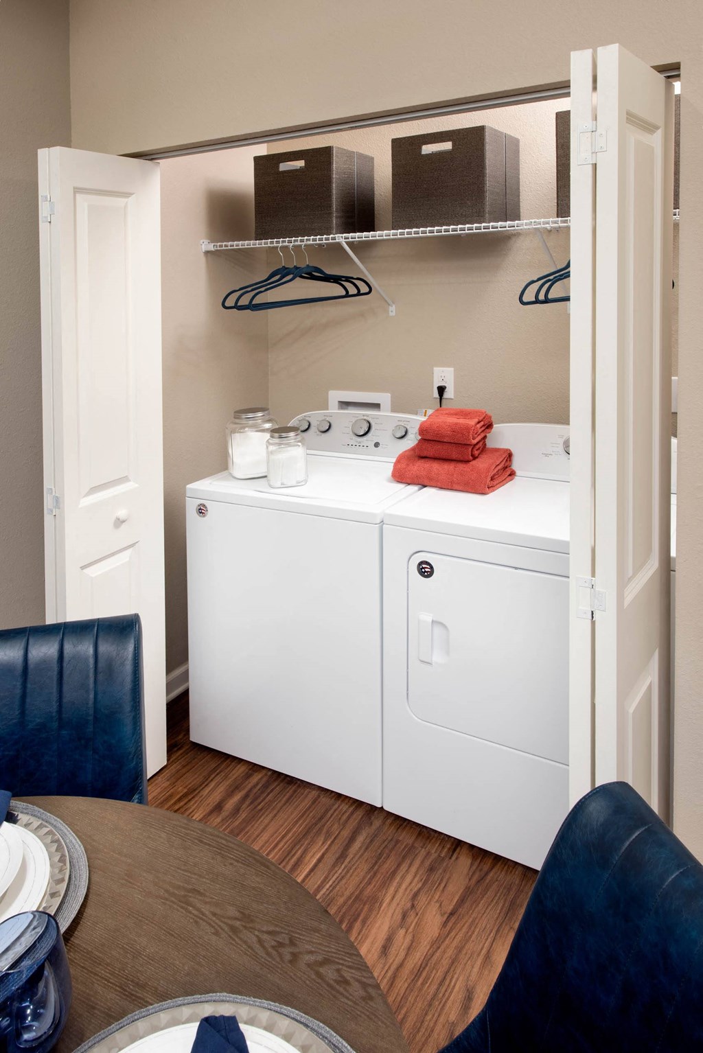 a washer and dryer in a room with a table and chairs