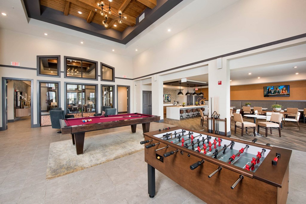 a game room with two pool tables and a foosball table