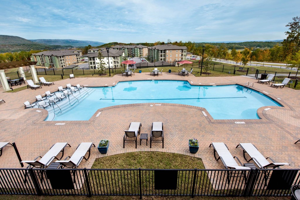 an aerial view of an outdoor pool with chairs