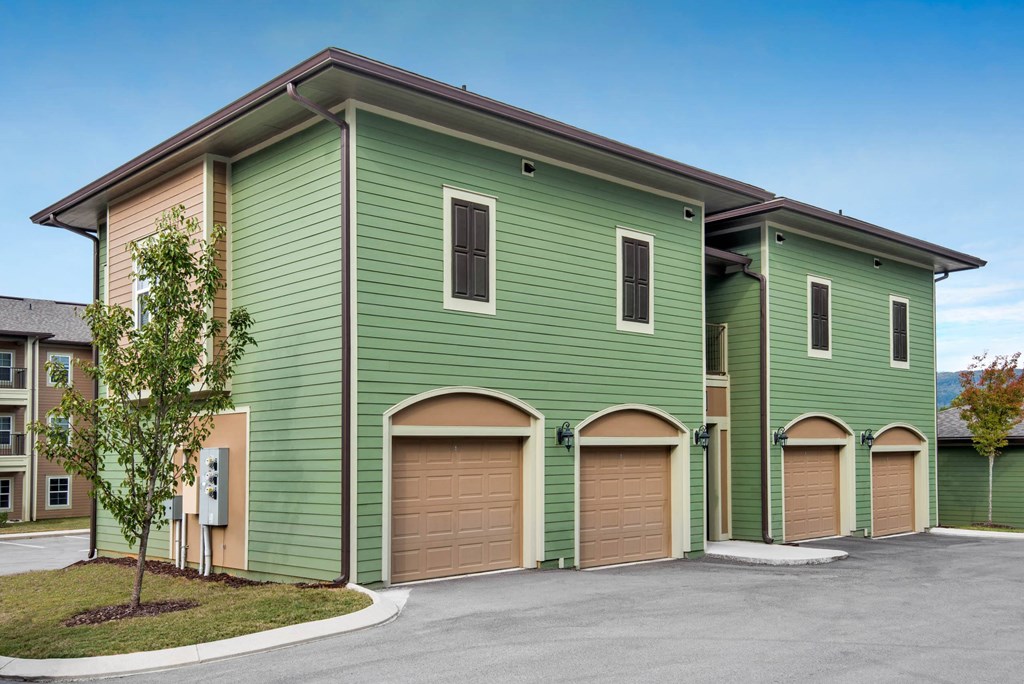 a green building with three garage doors