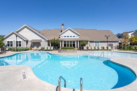 A large swimming pool in front of a house.