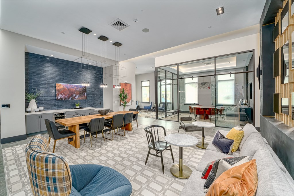 a living room with couches and chairs and a dining room with tables at Lyric at Norton Commons Apartments, Prospect, 40059