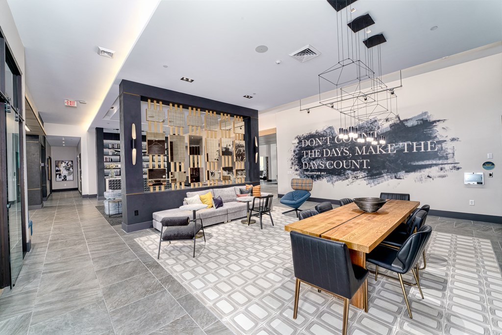 a dining room with a wooden table and chairs and a living room with couches at Lyric at Norton Commons Apartments, Prospect, 40059