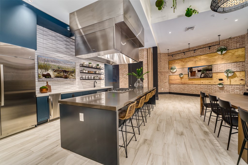 a kitchen with stainless steel appliances and a long island with chairs at Lyric at Norton Commons Apartments, Prospect, KY