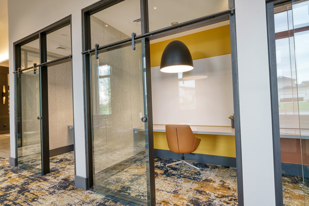a conference room with a yellow accent wall and glass sliding doors at Lyric at Norton Commons Apartments, Prospect, 40059