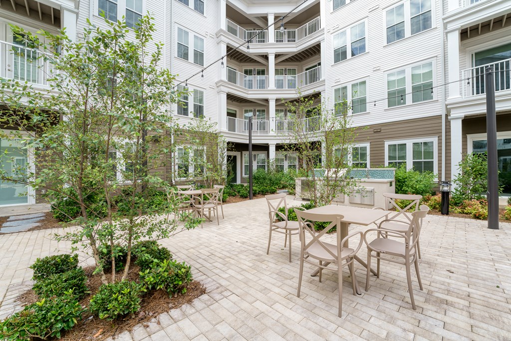 a patio with a table and chairs in a courtyard at Lyric at Norton Commons Apartments, Prospect, KY