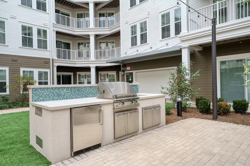 an outdoor kitchen with stainless steel appliances in front of a house at Lyric at Norton Commons Apartments, Prospect, 40059