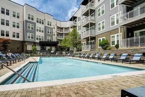 A large swimming pool surrounded by apartment buildings.