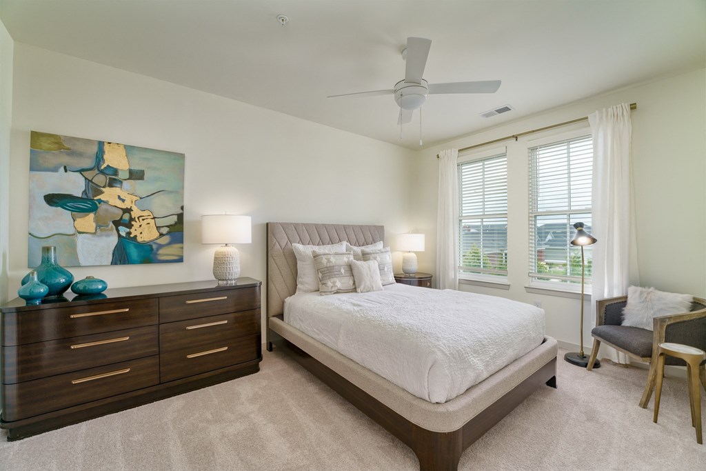 a bedroom with a bed and a dresser and a ceiling fan at Lyric at Norton Commons Apartments, Prospect, Kentucky