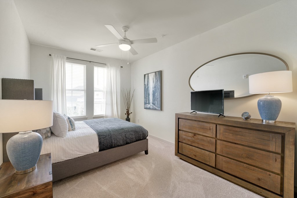 a bedroom with a bed and a dresser with a mirror at Lyric at Norton Commons Apartments, Prospect, 40059