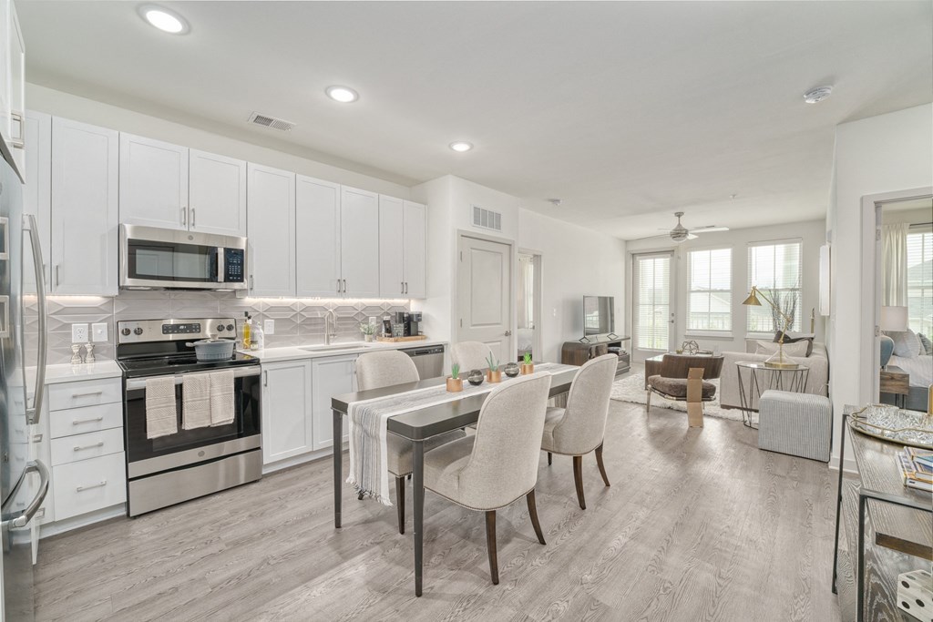 a kitchen with white cabinets and a table with chairs at Lyric at Norton Commons Apartments, Prospect, 40059