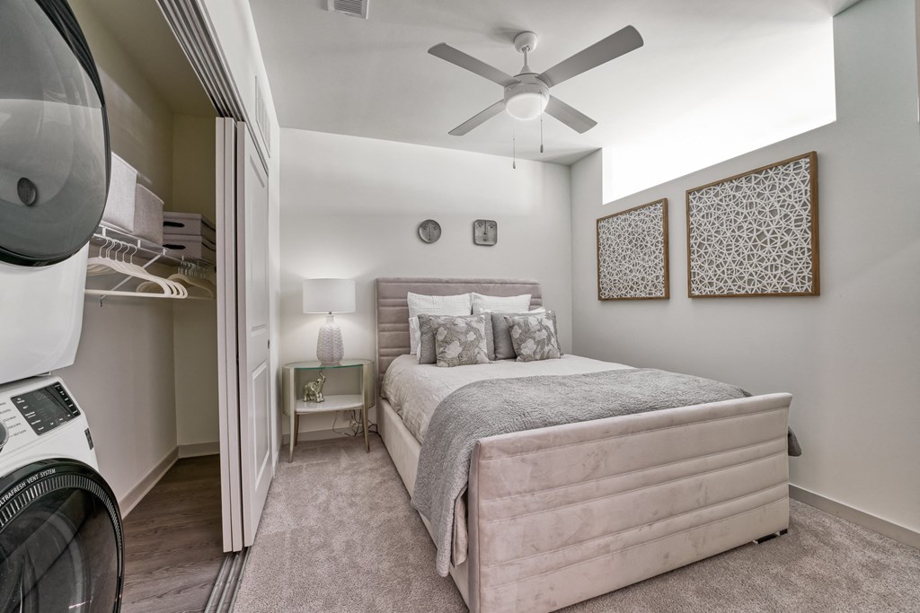a bedroom with a bed and a washer and dryer at Lyric at Norton Commons Apartments, Prospect, KY