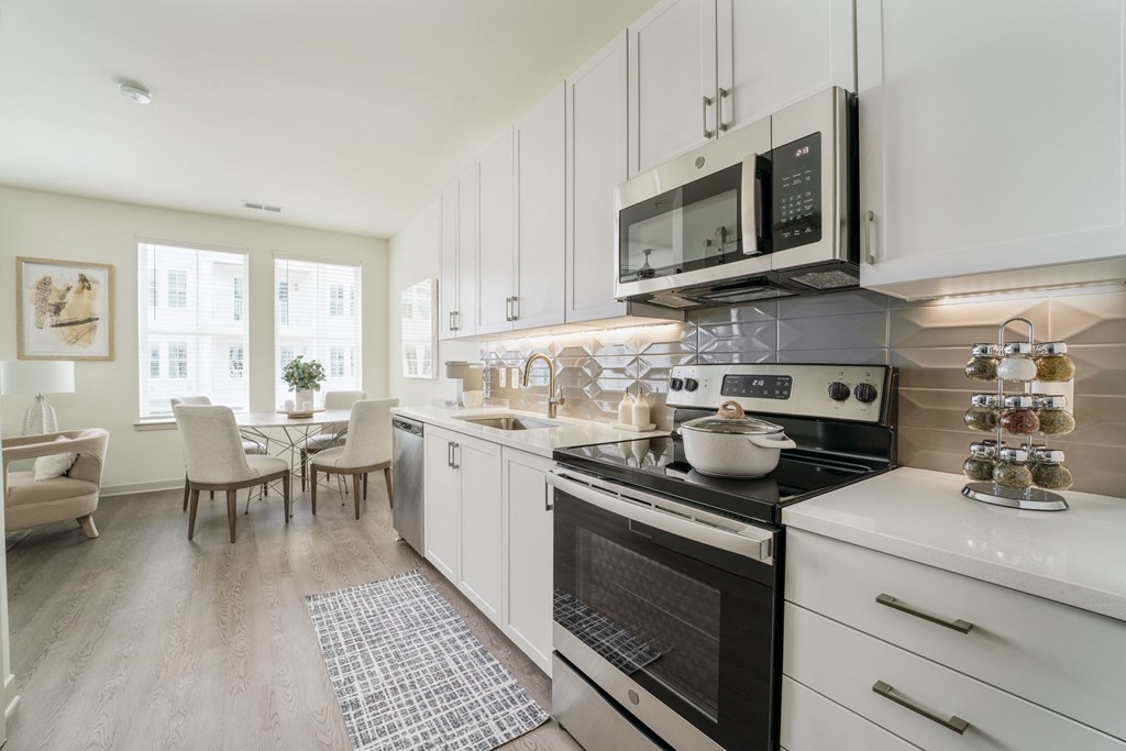 a kitchen and dining room with pink and white walls at Lyric at Norton Commons Apartments, Prospect, Kentucky