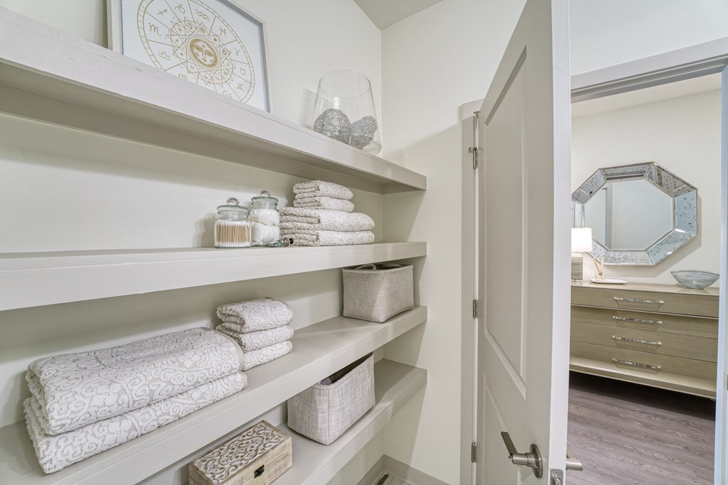 a bathroom with shelves filled with towels and a closet at Lyric at Norton Commons Apartments, Prospect, Kentucky