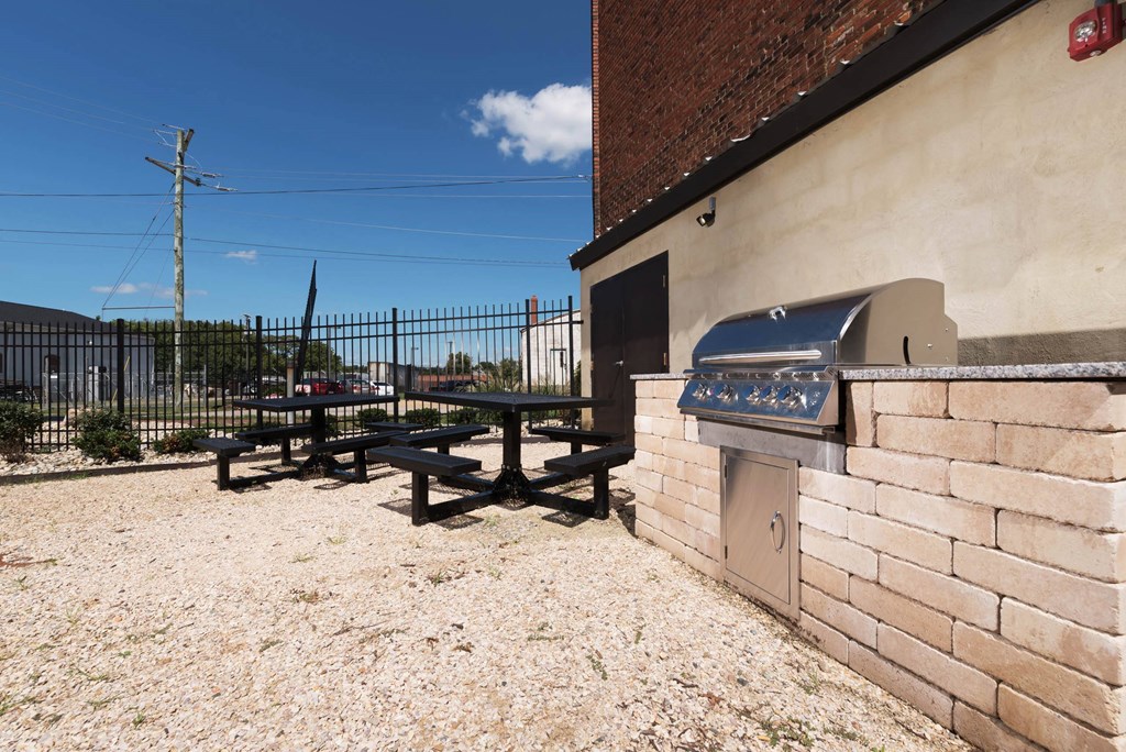 a barbecue grill and picnic table outside of a building at Mayton Transfer Lofts, Petersburg, 23803